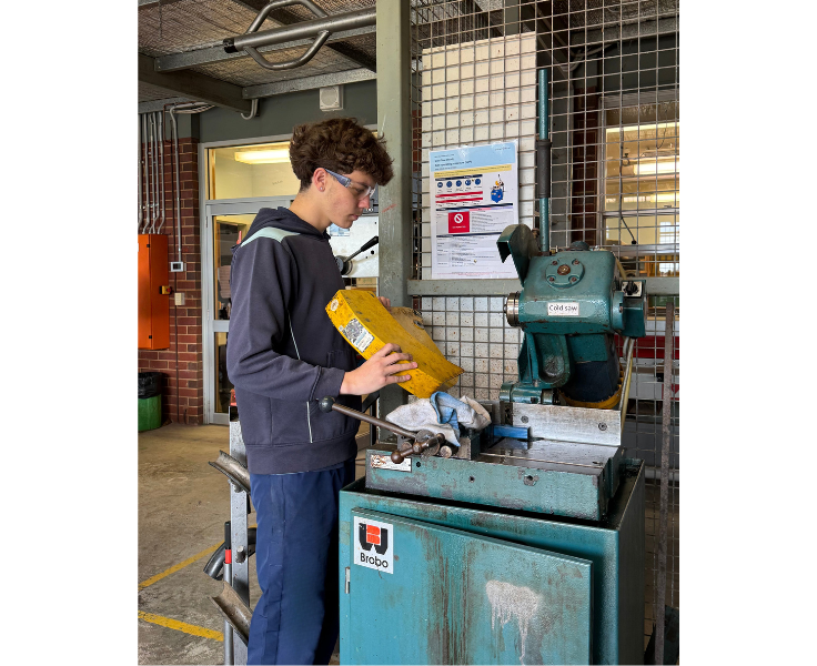 Secondary student in the technical workshop cleaning up the machinery