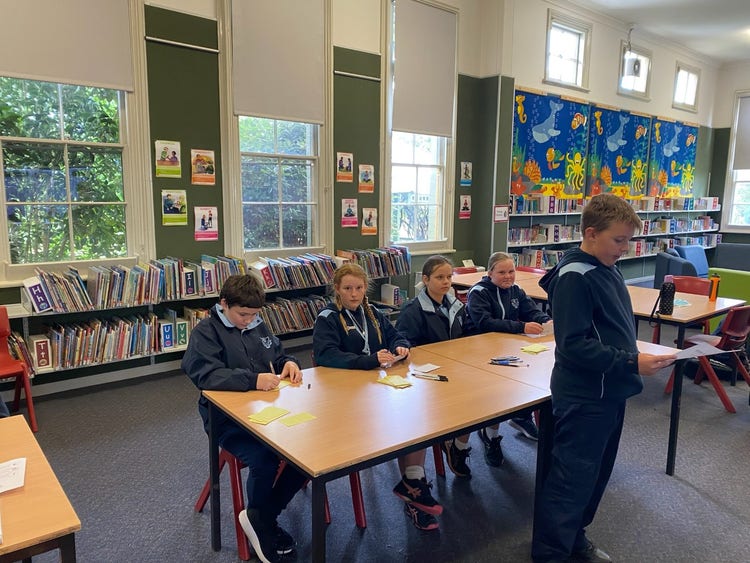 Primary debating team giving their argument in the school library