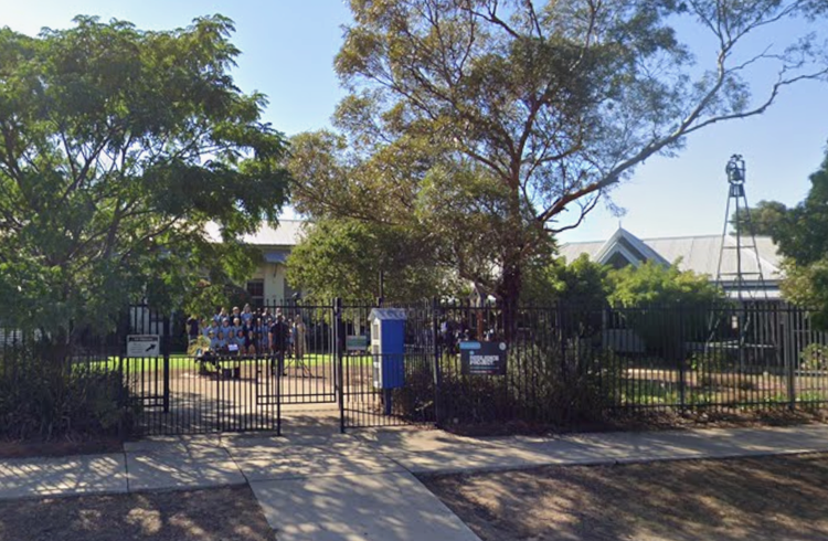 View of the main entrance to Coolamon Central School. Students can be seen having their class photos taken.