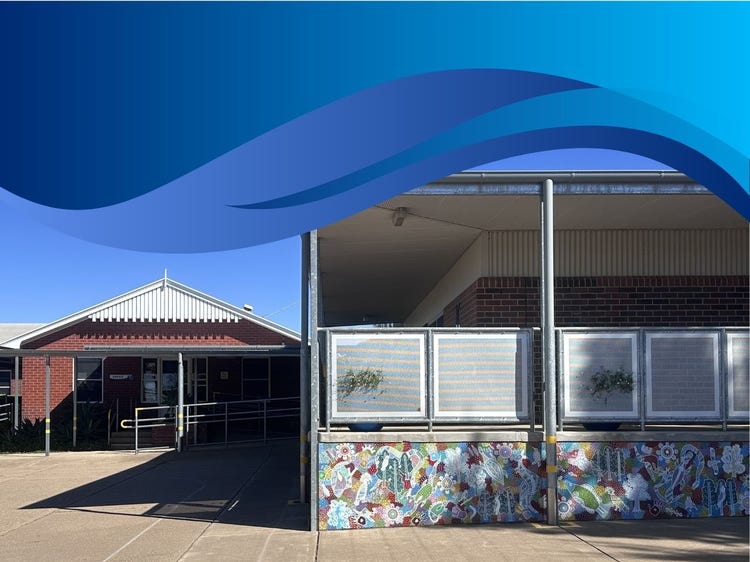 Photo of school quad showing our colourful Aboriginal mural painted on the library balcony
